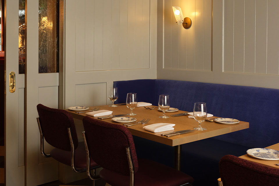 Cozy interior of Felicia Suzanne's Restaurant featuring large windows, intimate table settings, and soft natural light